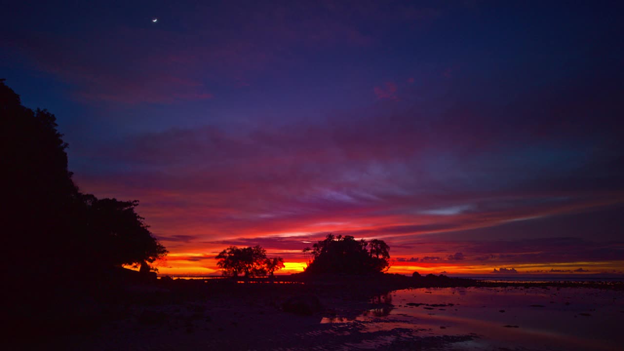 这是黎明时分退潮时宁静的海景，宁静的天空从黑夜过渡到白天。视频素材