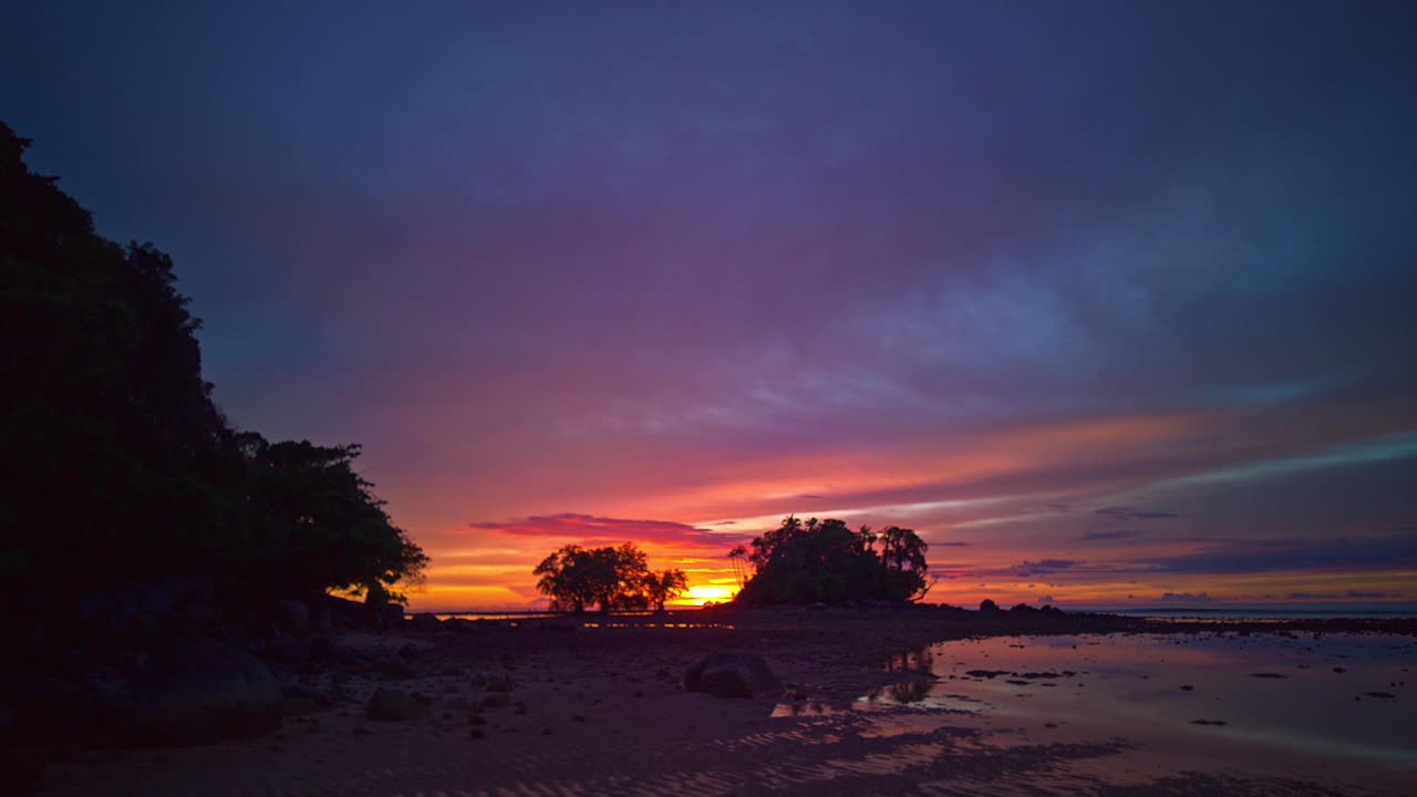 这是黎明时分退潮时宁静的海景，宁静的天空从黑夜过渡到白天。视频素材