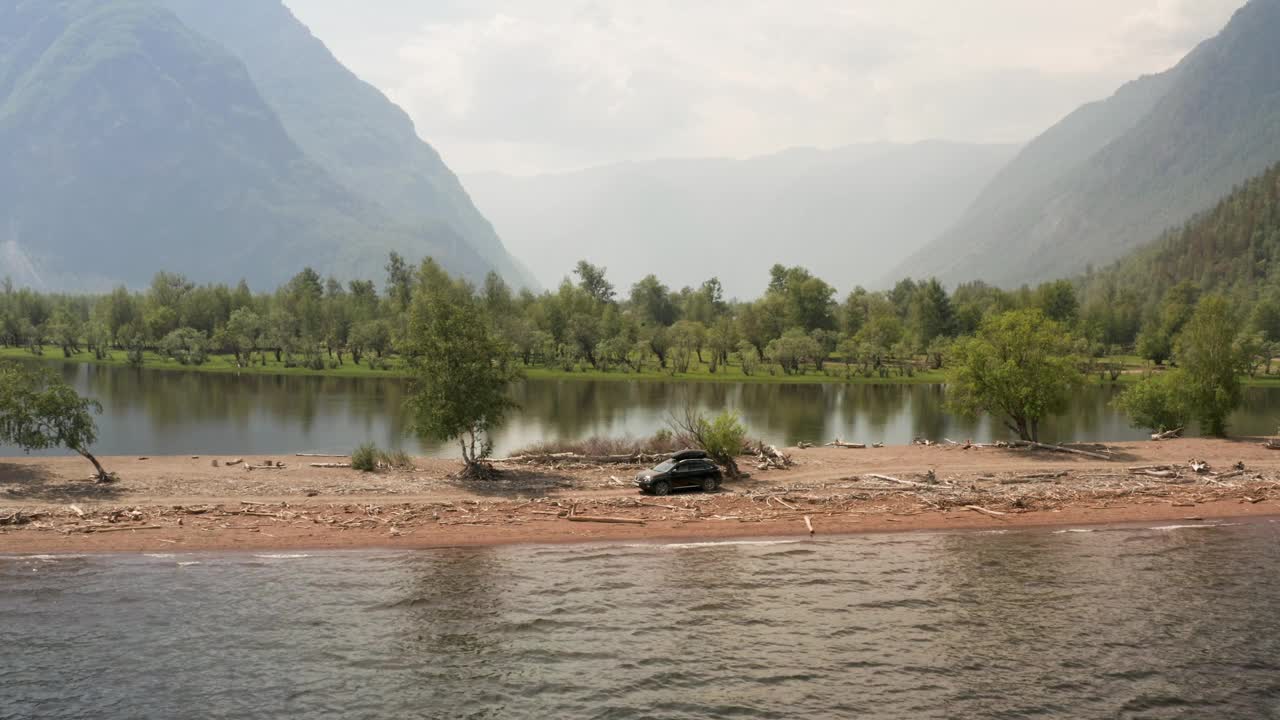 在美丽的山路上开车。自驾游概念。山林湖泊景观。在湖边岬角上行驶的汽车。汽车的鸟瞰图。视频下载