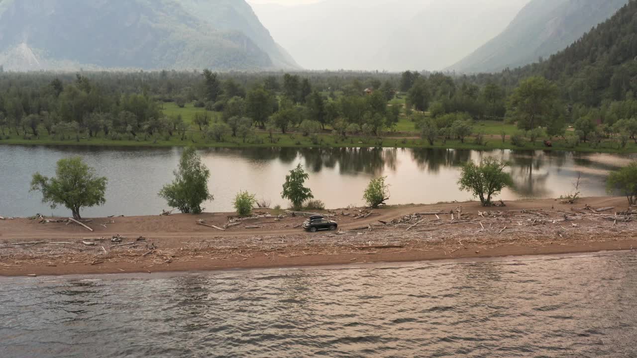 在美丽的山路上开车。自驾游概念。山林湖泊景观。在湖边岬角上行驶的汽车。汽车的鸟瞰图。视频素材