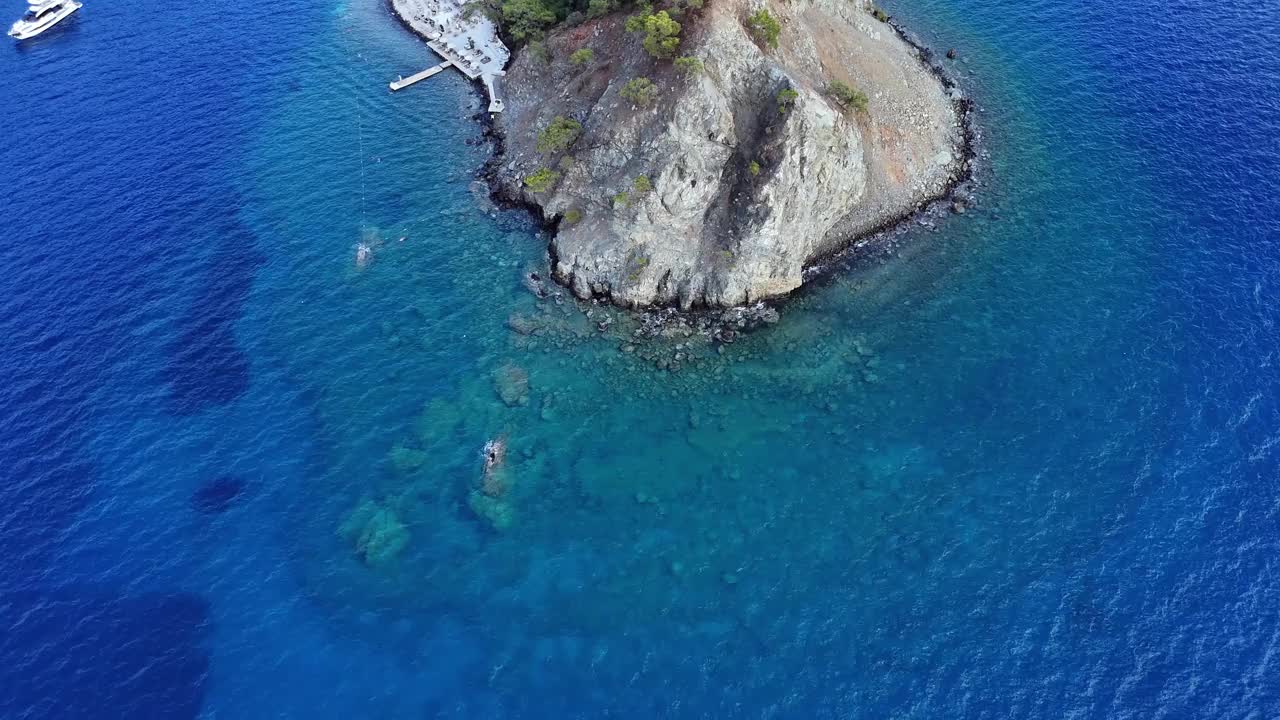 4k无人机拍摄的由岩石组成的半岛被大海包围，海的内部，即半岛在海底的部分，也可以从上面向右平移视频素材