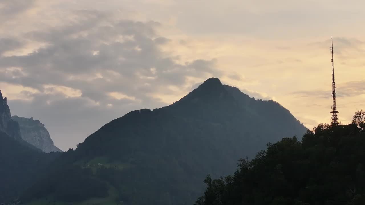 无人机拍摄的传输塔剪影映衬着瑞士山区的日落景观。从空中俯瞰，令人惊叹的景色。格拉鲁斯北部视频素材