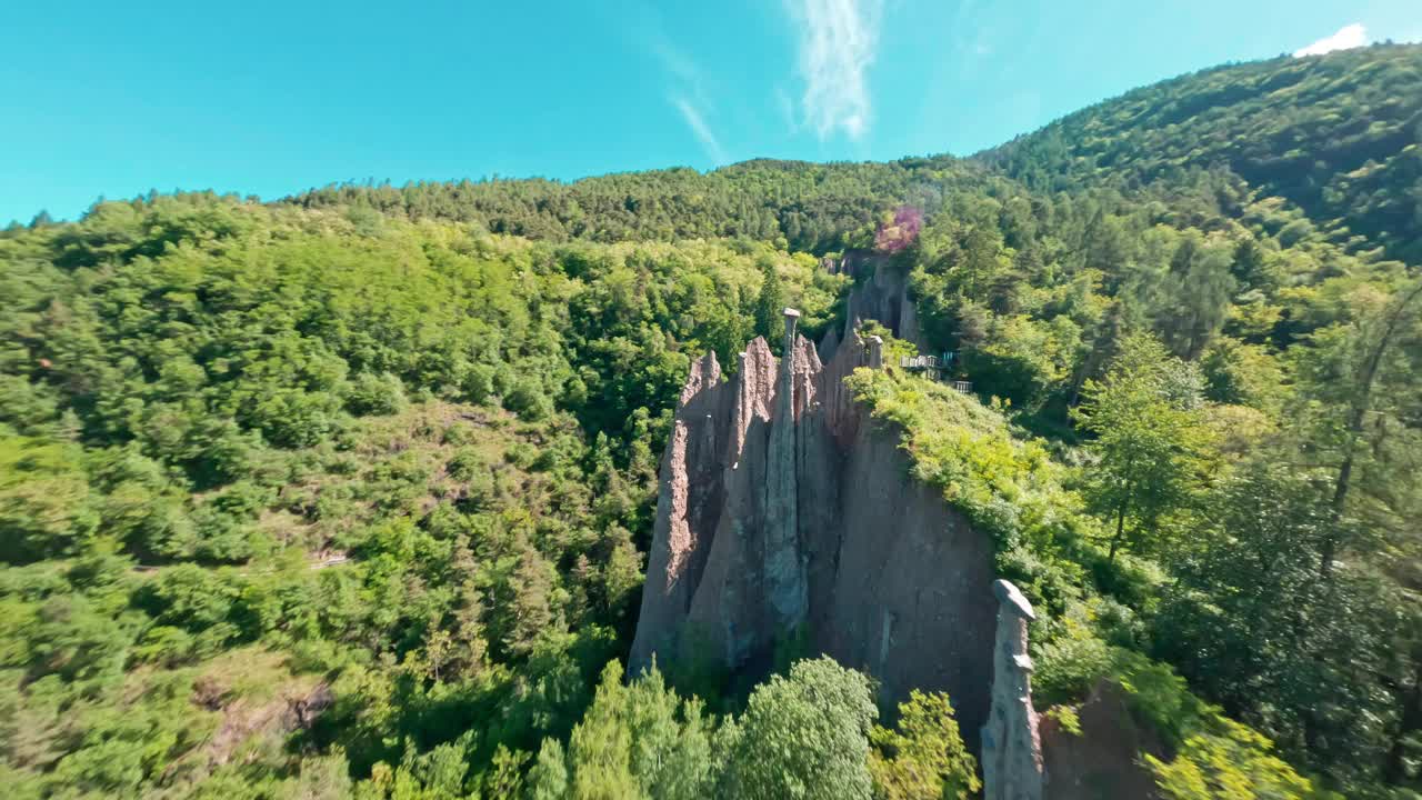 独特的岩层在明亮的蓝天下从郁郁葱葱的青山中升起视频素材