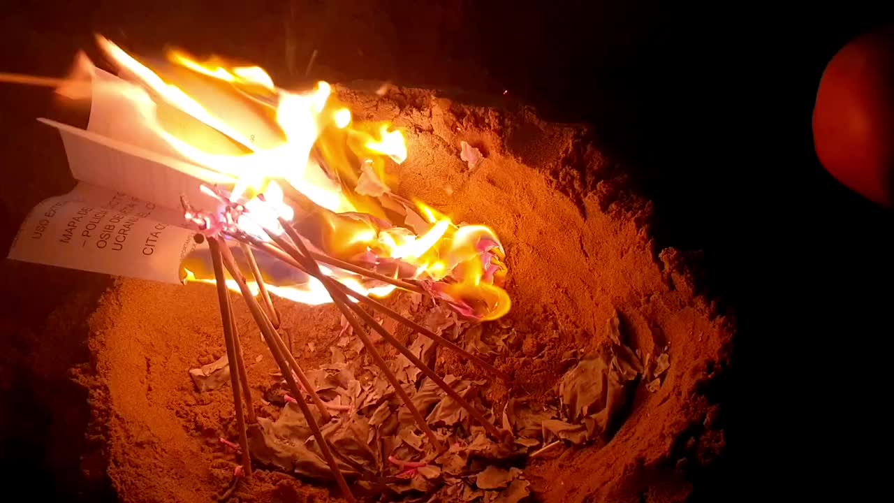 晚上在沙滩上营火。在火中燃烧木头。野外沙滩上的小营火。橙色的火焰。视频下载