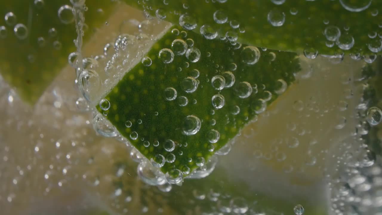 极端宏观特写的柠檬片在一个玻璃杯与碳酸水泡沫-股票视频视频素材