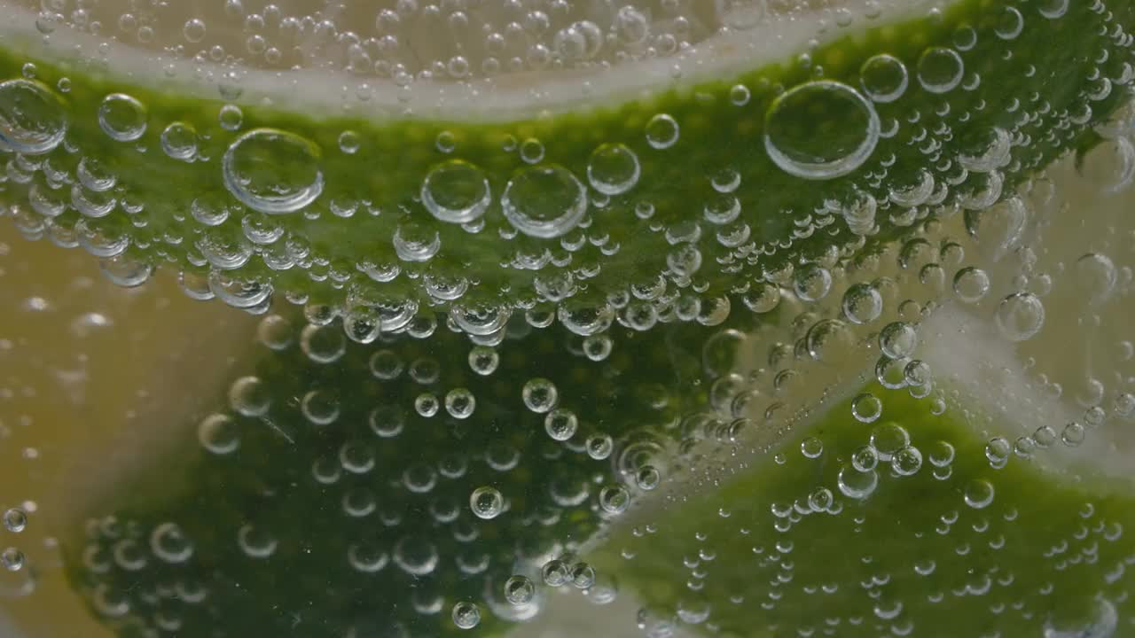 极端宏观特写的柠檬片在一个玻璃杯与碳酸水泡沫-股票视频视频素材