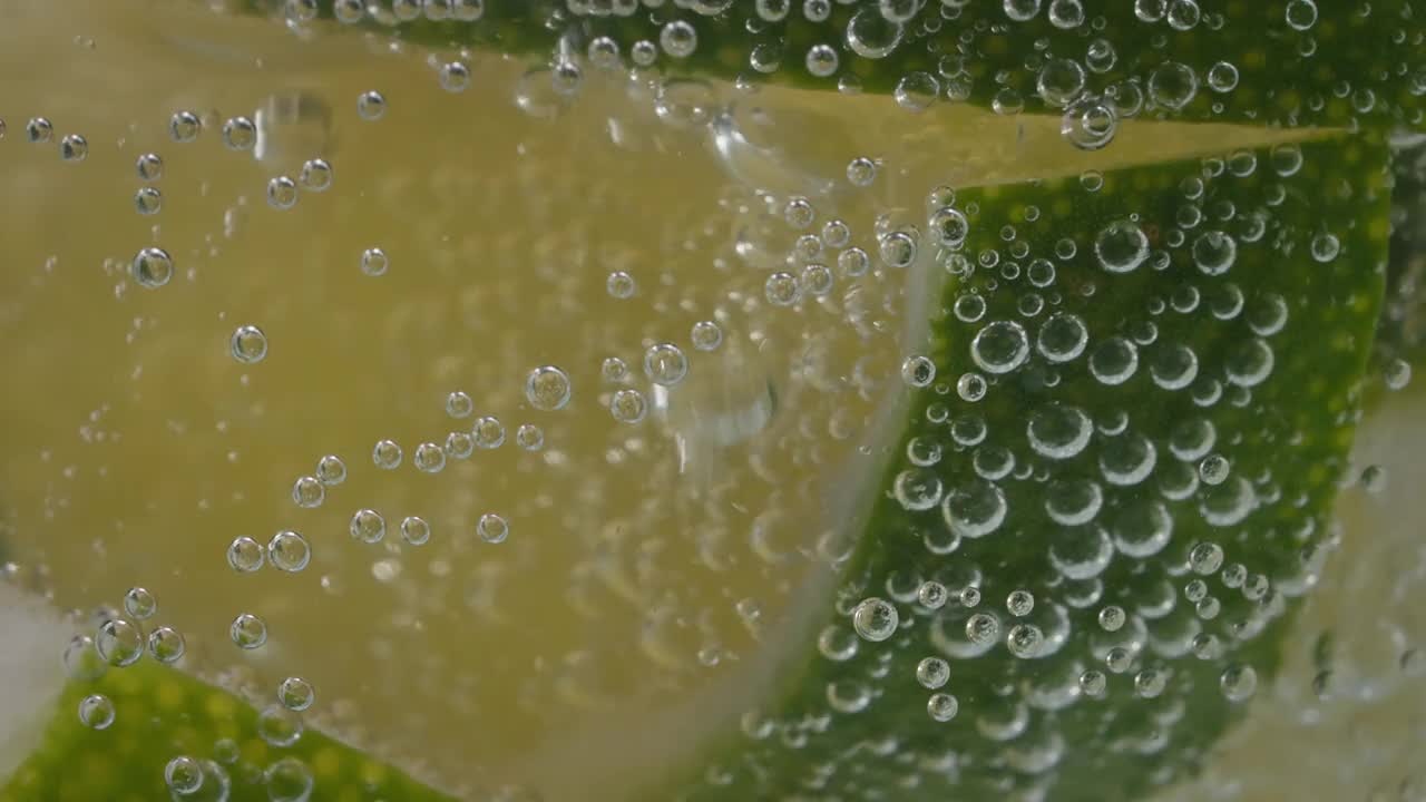 极端宏观特写的柠檬片在一个玻璃杯与碳酸水泡沫-股票视频视频素材