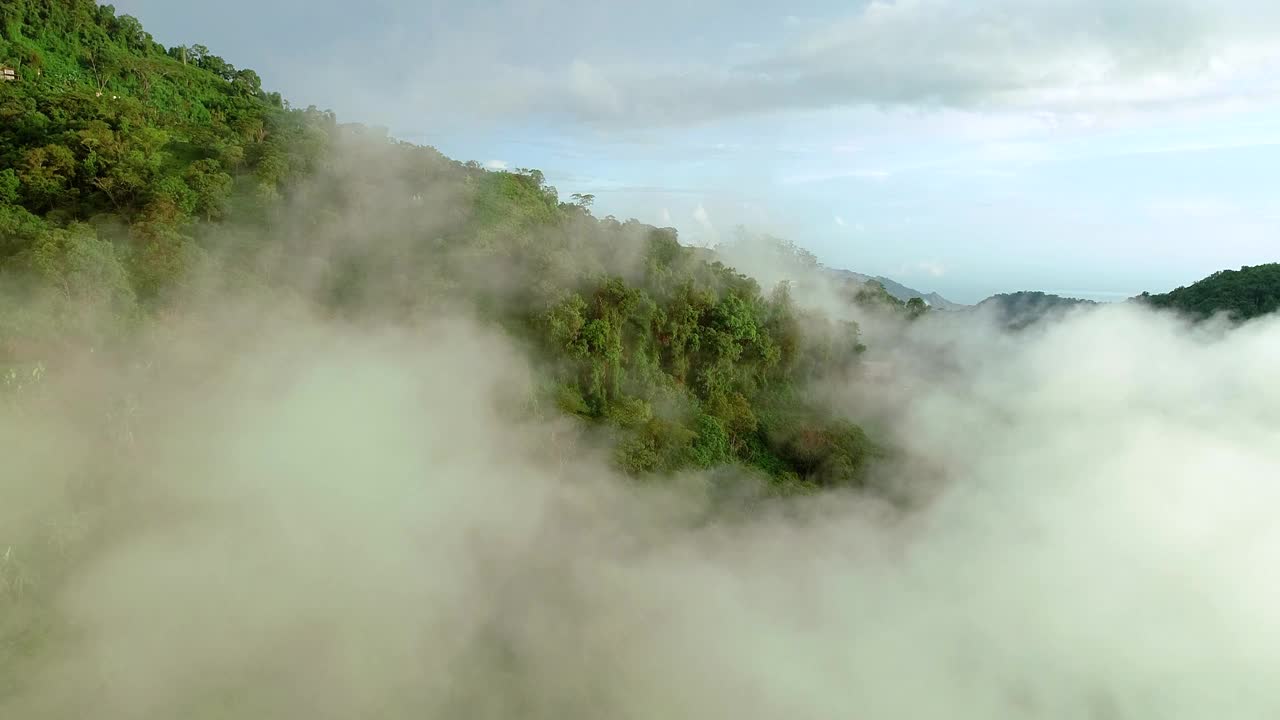 无人机在哥伦比亚雨林覆盖的山脉上空飞过云层。视频素材