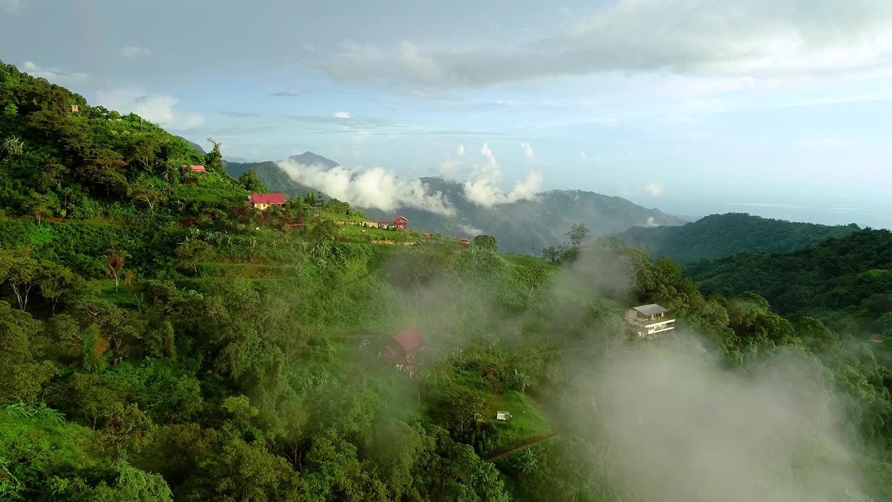 在哥伦比亚农村热带山脉的绿色山坡上随意的别墅，航拍。视频素材