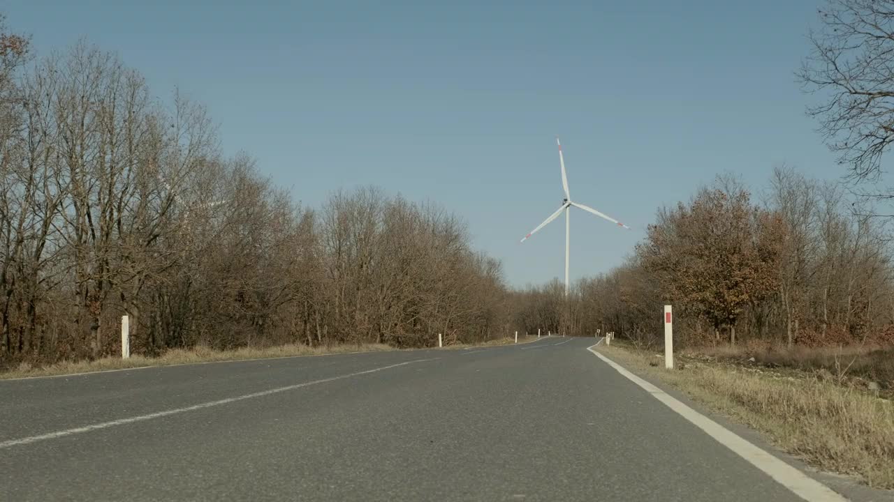 远处有风力涡轮机的乡村公路视频下载