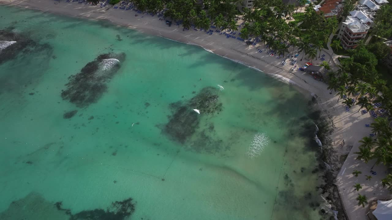 Bayahibe海岸线的俯视图，航拍清澈的海洋，美丽的沙滩和背景树木和度假村。多米尼加共和国。视频素材