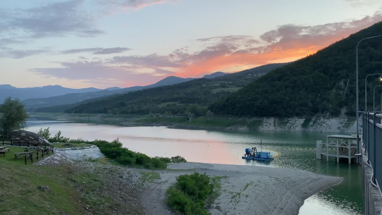 在意大利皮亚琴察的米尼亚诺大坝上，有船和风景优美的山湖上宁静的日落视频下载