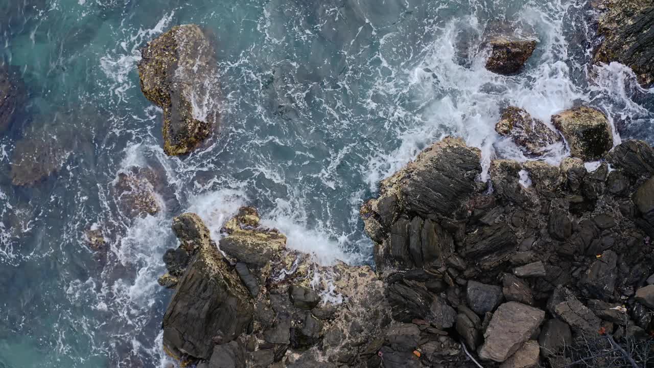 日出时，海浪拍打着岩石海岸视频下载