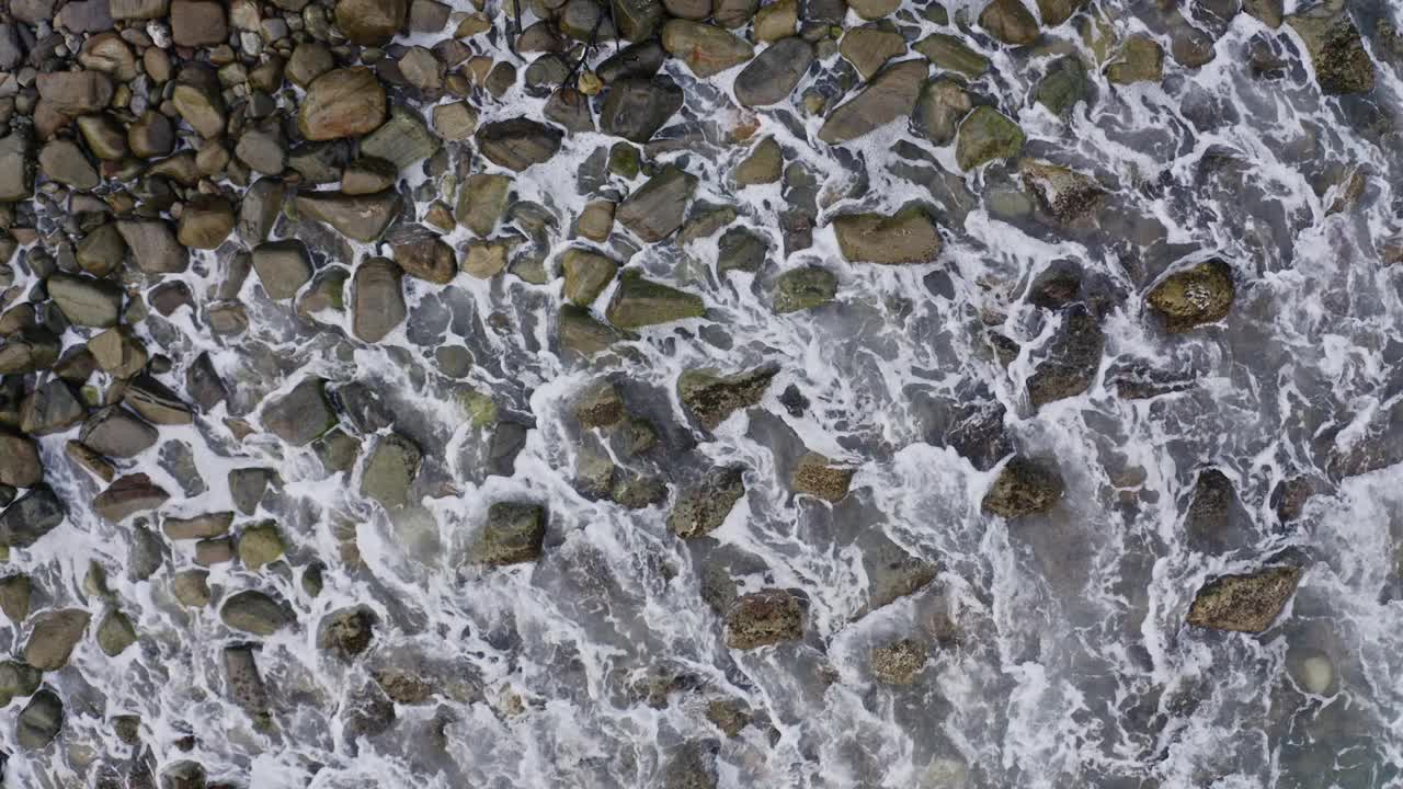 日出时，海浪拍打着岩石海岸视频下载