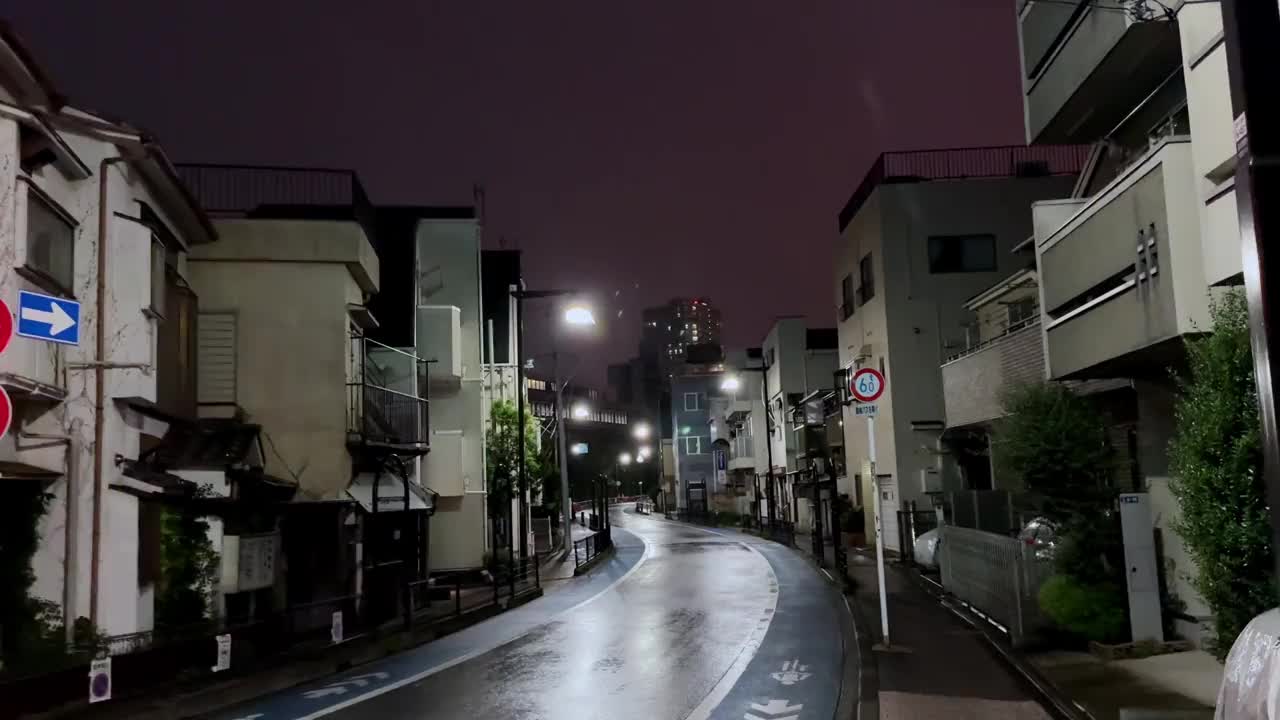 雨夜，东京品川区空荡荡的街道，潮湿的路面反射着城市的灯光视频素材