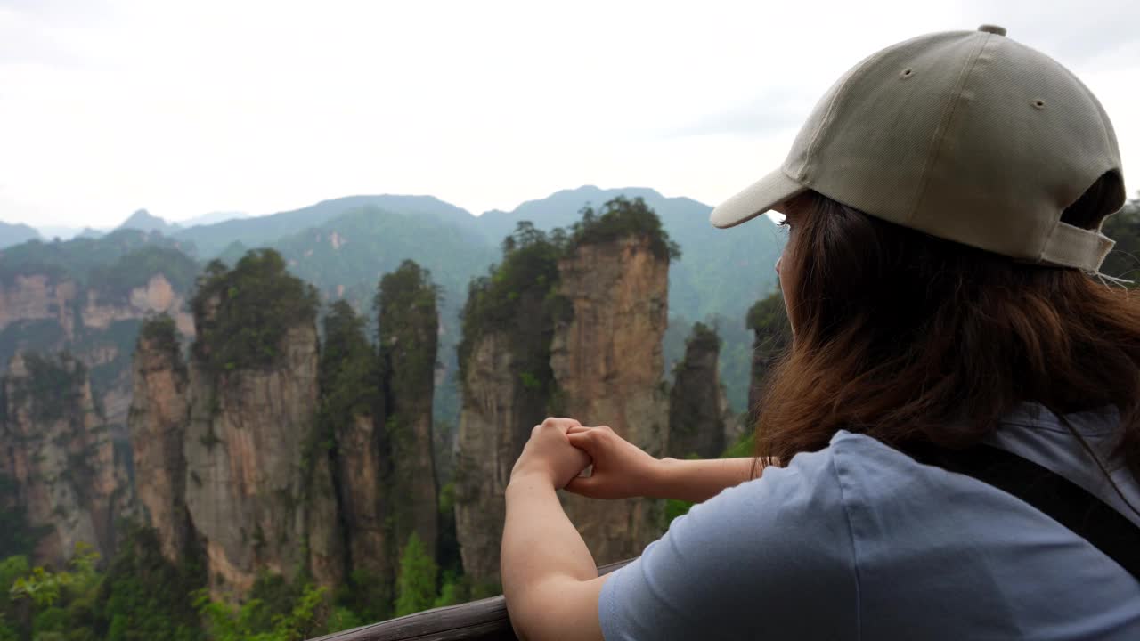 一名女子在欣赏中国黄石村雄伟的五指峰景观视频素材