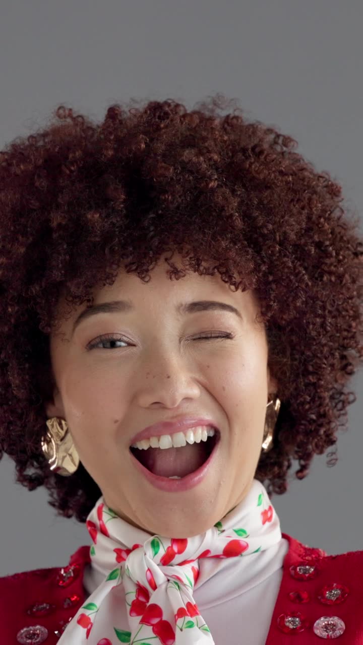快乐的女性，面部特写和非洲卷发，身着时尚服装，背景为灰色，适合风格、美丽或表现。肖像，女性或模特，带着微笑、眨眼或发型，营造复古或怀旧的氛围。视频素材画面1