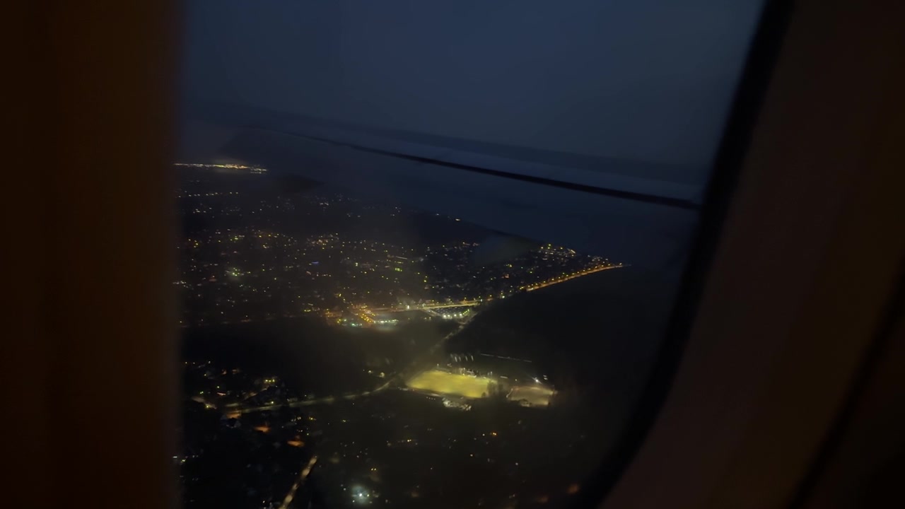 从飞机窗户拍摄的飞行中城市夜景航拍视频素材画面1
