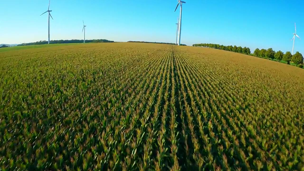 电影感FPV穿越机飞行，围绕德国乡村的草垛和风力涡轮机视频素材画面4