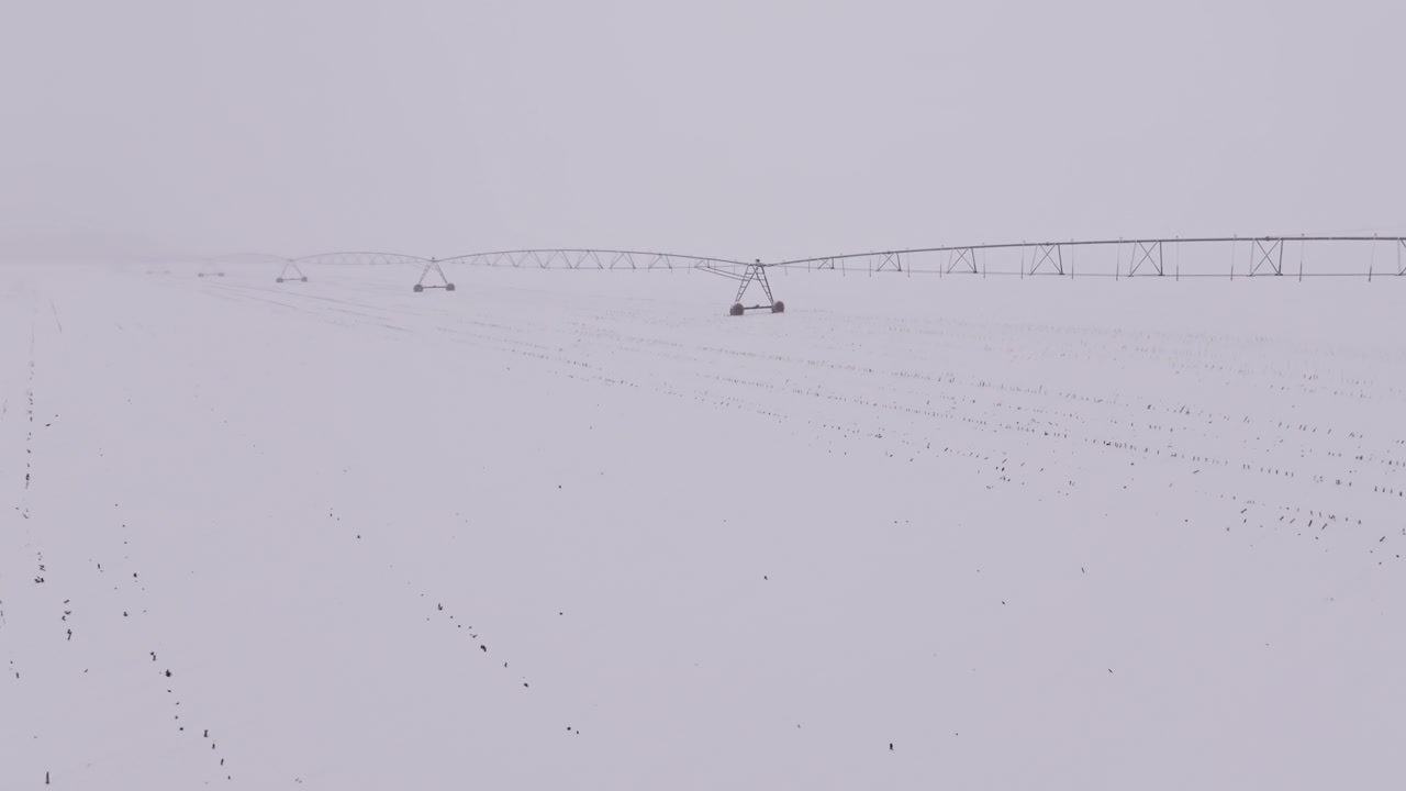 冬季，灌溉中心支轴系统矗立在雪后的农田里视频素材画面2