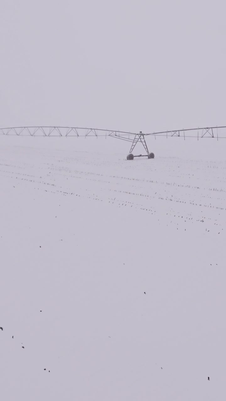 冬季，灌溉中心支轴系统在覆盖着雪的农田里闲置着视频素材画面2