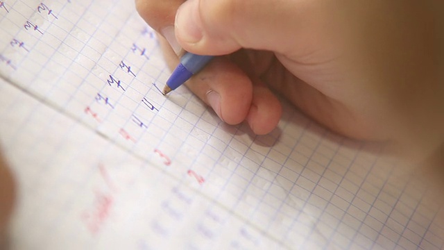 写作的第一步:小学生在方格笔记本上写数字视频素材画面1