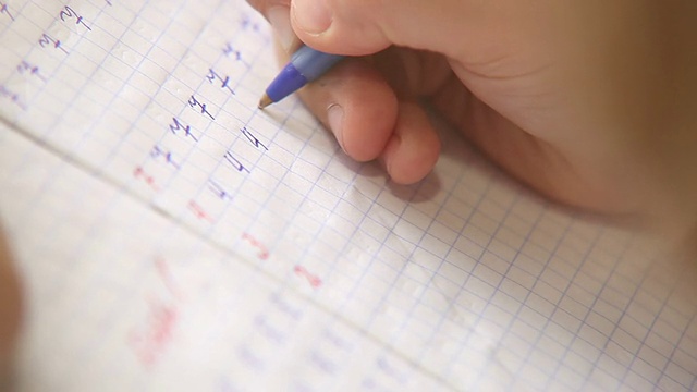 写作的第一步:小学生在方格笔记本上写数字视频素材画面2
