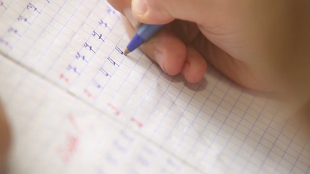 写作的第一步:小学生在方格笔记本上写数字视频素材画面3