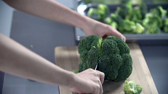 一个女人在桌上切花椰菜视频素材画面4