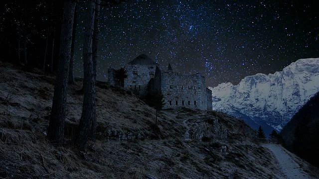 时间推移-惊人的夜空与一条路径通往一个石头建筑废墟。背景是美丽的白雪覆盖的阿尔卑斯山视频素材