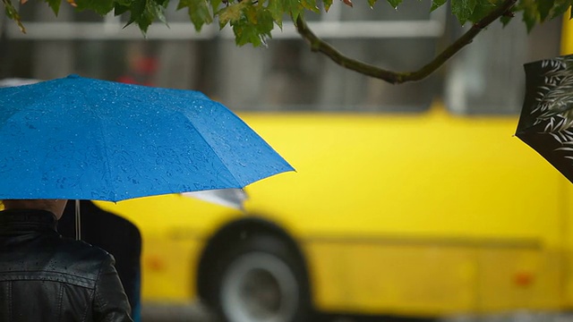 在城市街道上打着雨伞的人们视频素材