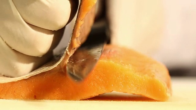 厨师在餐厅厨房的砧板上切三文鱼片视频素材画面1