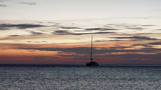 4K延时拍摄的夕阳在Koh Chang海滩，锚定的船漂浮。视频下载