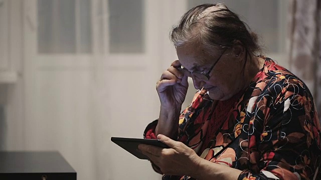 孤独的祖母在用平板电脑视频素材画面1