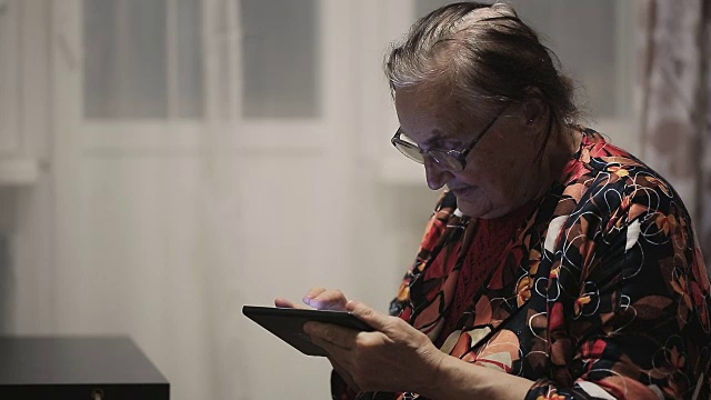 孤独的祖母在用平板电脑视频素材画面3