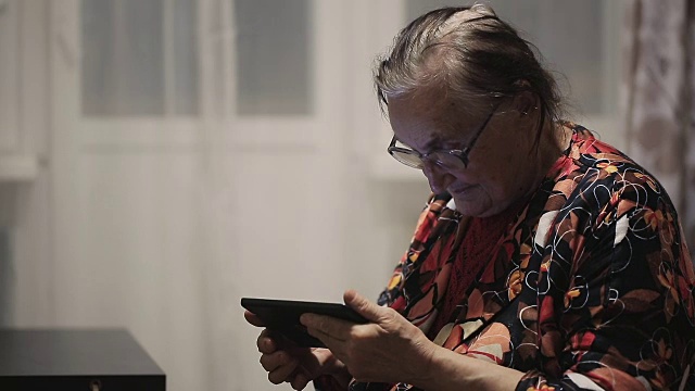 孤独的祖母在用平板电脑视频素材画面4