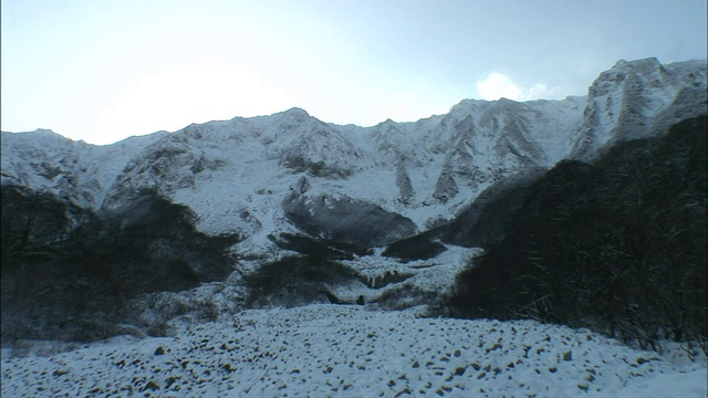 大雪覆盖了大山脚下的一个山谷。视频素材