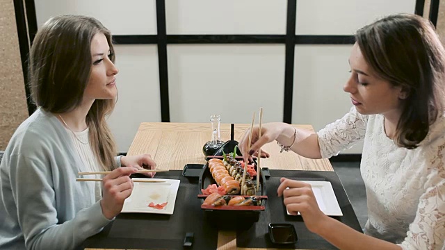 两个女孩在餐厅吃饭时聊天视频素材