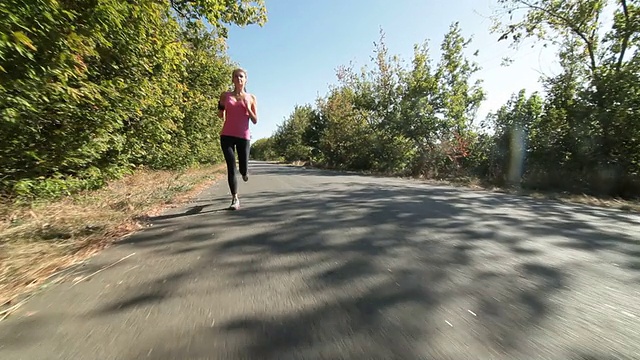 运动的年轻女子在路上慢跑视频素材