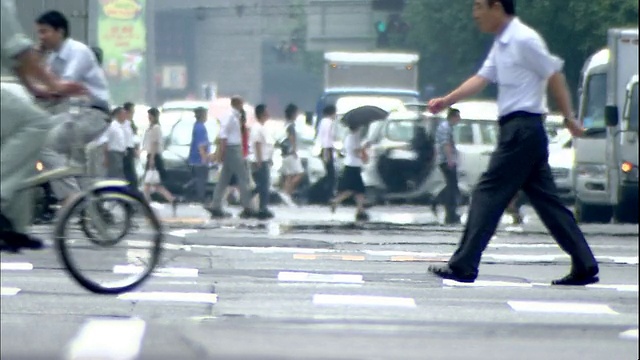 在日本东京，交通和行人通过一个十字路口。视频素材