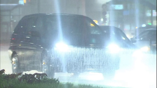 行人在暴雨的夜晚在人行横道上过马路。视频素材