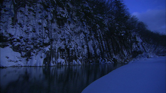 日本岩手山陡峭的雪坡从一个平静的湖里垂直升起。视频素材