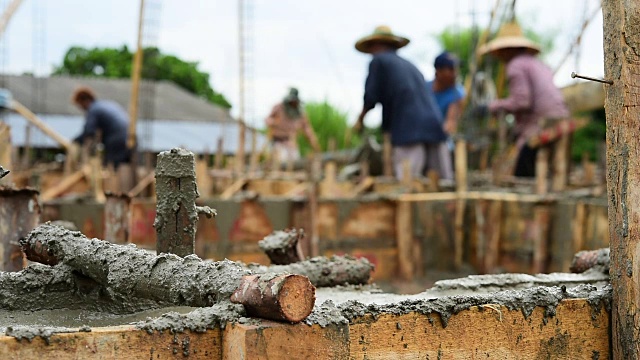 工人们为房屋建筑浇筑水泥地基视频素材