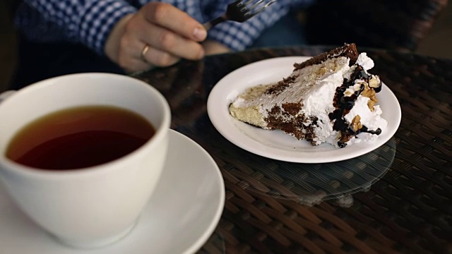 一个女人在餐厅边喝茶边吃蛋糕视频素材