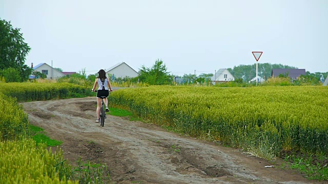 健康的生活方式妇女骑自行车在农村道路上视频素材