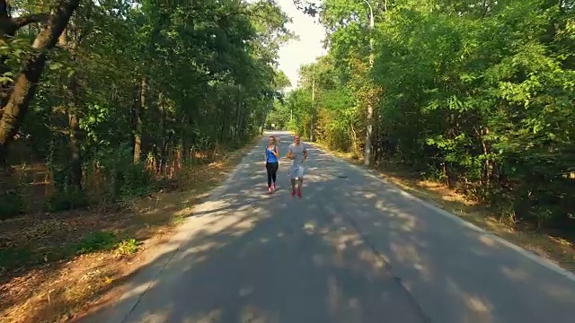 航拍一男一女在公园里一起跑步视频素材