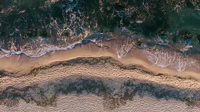 海浪、海水和沙滩鸟瞰图。透视是垂直向下的。视频素材