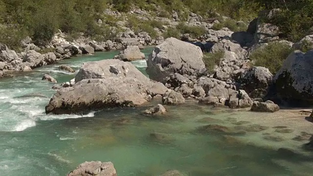 空中，近距离:美丽的翡翠维持河流之间的尖锐的岩石视频素材