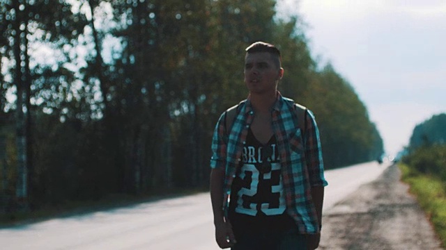 心烦意乱的男人背着背包走在路上。搭便车。拇指。旅行者视频素材画面4