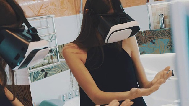 女孩戴着虚拟现实眼镜站在浴室的镜子前视频素材画面2